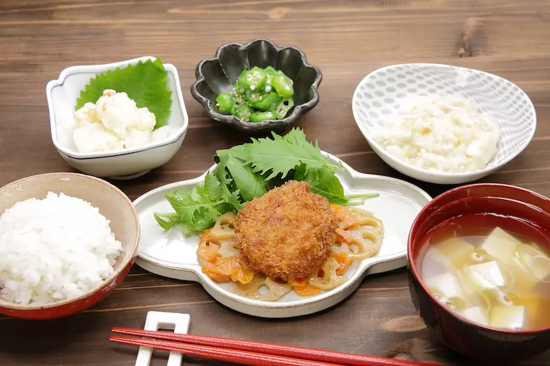 Dr.つるかめキッチンのたんぱく質・塩分制限メニュー「チキンカツ御膳」。レンコン炒めを添え、バランスの取れた副菜と味噌汁付き。